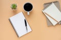 Top view of open school notebook with blank pages and pen, pencil with coffee cup on brown background. Royalty Free Stock Photo