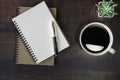 Top view of open school notebook with blank pages, Pen, Plant and Coffee cup on wooden table background. Business, office or educa Royalty Free Stock Photo