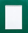 Top view of a open spiral notebook on green background