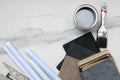Top view of opened can of grey paint, brush, fabric swatches, project planning tools on the marble surface.Empty space Royalty Free Stock Photo