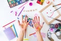 Top view opened painted female hands over Create word lettering with many colorful paintiing materials on white background. Create