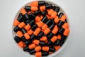 Top view of orange, black, capsule pills in plastic container Royalty Free Stock Photo