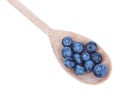 Top view of organic blueberries on a wooden spoon, isolated on a white background. Summer harvest. Close-up of sweet berries. Royalty Free Stock Photo