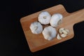 Top view organic bulb garlic and clove on wooden chopping block with black background, have space for text.