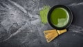 Top view on organic green matcha tea in black ceramic cup with bamboo whisk Royalty Free Stock Photo