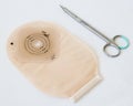 Top view on ostomy bag and scissors. Close-up on colostomy pouch in skin color - supply needed after colostomy surgery