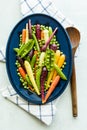 Top view of an oval dish filled with rainbow baby carrots, peas and pea pods. Royalty Free Stock Photo