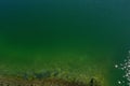 Top view over a chemical green lake in which the bottom quickly disappears in the depths of the water