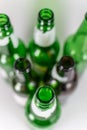 Top view of a pack of blurred empty green and brownlongneck beer glass bottles, with ripped labels on a white background Royalty Free Stock Photo