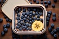 top view of a packed lunchbox with a banana and blueberries