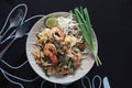 Top view of Pad Thai or Thai stir-fried noodles with shrimp on black table background. Thai foods concept Royalty Free Stock Photo