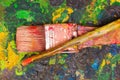Top view of paint brushes over a color palette in a blurred background