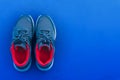 Top view pair of blue and red running sport shoes isolated on dark blue background with copy space. Healthy lifestyle and exercise