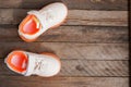 Top view of a pair of children sneakers on wooden floor , copy space
