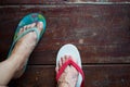 Top view pair of foot in the sandals stand on the wooden floor