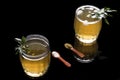 Top view of a pair of glass of Kahwa,Indian Kashmiri herbal summer tea topped with ice cubes and saffron on black background