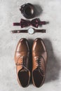 top view of pair of wedding shoes, bow tie and wristwatch