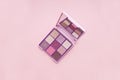 Top view Palette of pink cosmetic make up with a mirror on pink background, colorful shadows minimalism, on light pink background