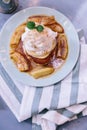 Top view of Pancakes with caramel-banana syrup topping with whip cream and mint leaves. In blue plate over fabric. Royalty Free Stock Photo