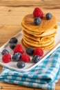 Top view of pancakes in stack with blueberries and raspberries on blue cloth Royalty Free Stock Photo