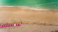 Top view of a Pandawa beach with many umbrellas and people relaxing.