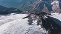 Top view of panorama of rocky mountains with snow on background blue sky. Clip. Snowy slopes with majestic rocky peaks