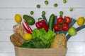 Paper bag of different health food on white wooden background. Top view Royalty Free Stock Photo