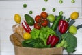 Paper bag of different health food on white wooden background. Top view Royalty Free Stock Photo