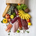 Top view, paper bag of healthy raw food on a white wooden table. Cooking food background. Fresh fruits, veggies, greens, different