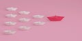 Top view of Paper boat leads pink followed by other white boat on a pink background