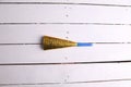 Top view of a party noisemaker isolated on a white wooden surface