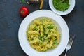 Top view of pasta pesto sauce served in a white plate on a black Royalty Free Stock Photo