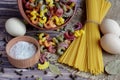 Top view of pasta, spaghetti, salt in a box, pepper and three eggs that lie in the center of a dark table Royalty Free Stock Photo