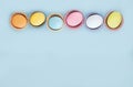 Top view pastel colors eggs row on a blue background