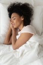 Top view of peaceful black girl sleeping in white bed