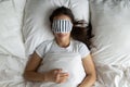 Top view peaceful young woman wearing mask sleeping in bed