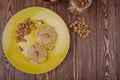 top view of peanut butter with almond on crispy rice crackers on a yellow ceramic plate with scattered almond on wooden background Royalty Free Stock Photo