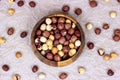 Top view of peeled brown hazelnuts in round wooden bowl on light background. Royalty Free Stock Photo