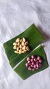 Top view peeled garlic and onion on banana leaf isolated white