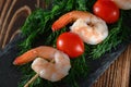 Top view of peeled shrimps and red tomato on a wooden stick and dill