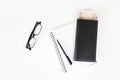 The top view of the pen and the money in a black leather bag placed on a book with eye glasses on a white table. With copy space Royalty Free Stock Photo