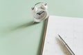 Pen on white open planner with a light green background and blurred clock in soft focus. For planning business, Royalty Free Stock Photo