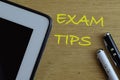 Top view of pen on wooden background written with EXAM TIPS