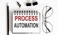 Top view ,pencil,glasses and notebook written PROCESS AUTOMATION on white background Royalty Free Stock Photo