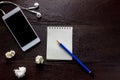 Top view pencil,note paper,white smartphone,black coffee,earphon