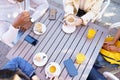 Top view of people drinking coffee, juice and tea sitting at the table on the terrace of a bar.