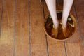 Top view of people soaking their legs in herbal water for foot spa treatment for healthy feet.