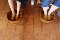 Top view of people soaking their legs in herbal water for foot spa treatment for healthy feet.