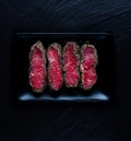 Top view on pepper steaks on black stone plate Royalty Free Stock Photo