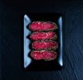 Top view on pepper steaks on black stone plate Royalty Free Stock Photo